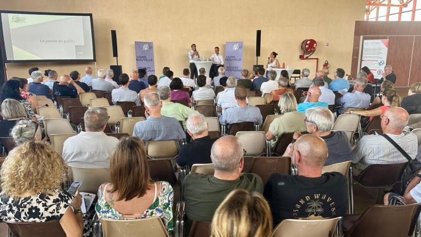 salle avec 100 personnes qui assistent à une réunion